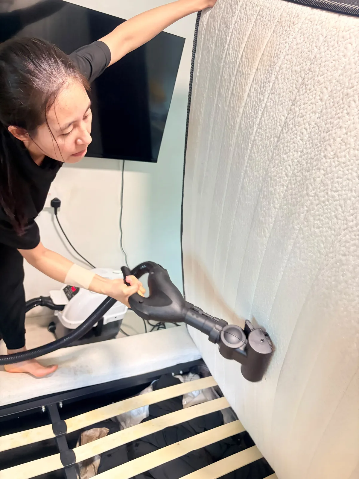 Mattress deep cleaning in progress — extraction tool treating side panel
