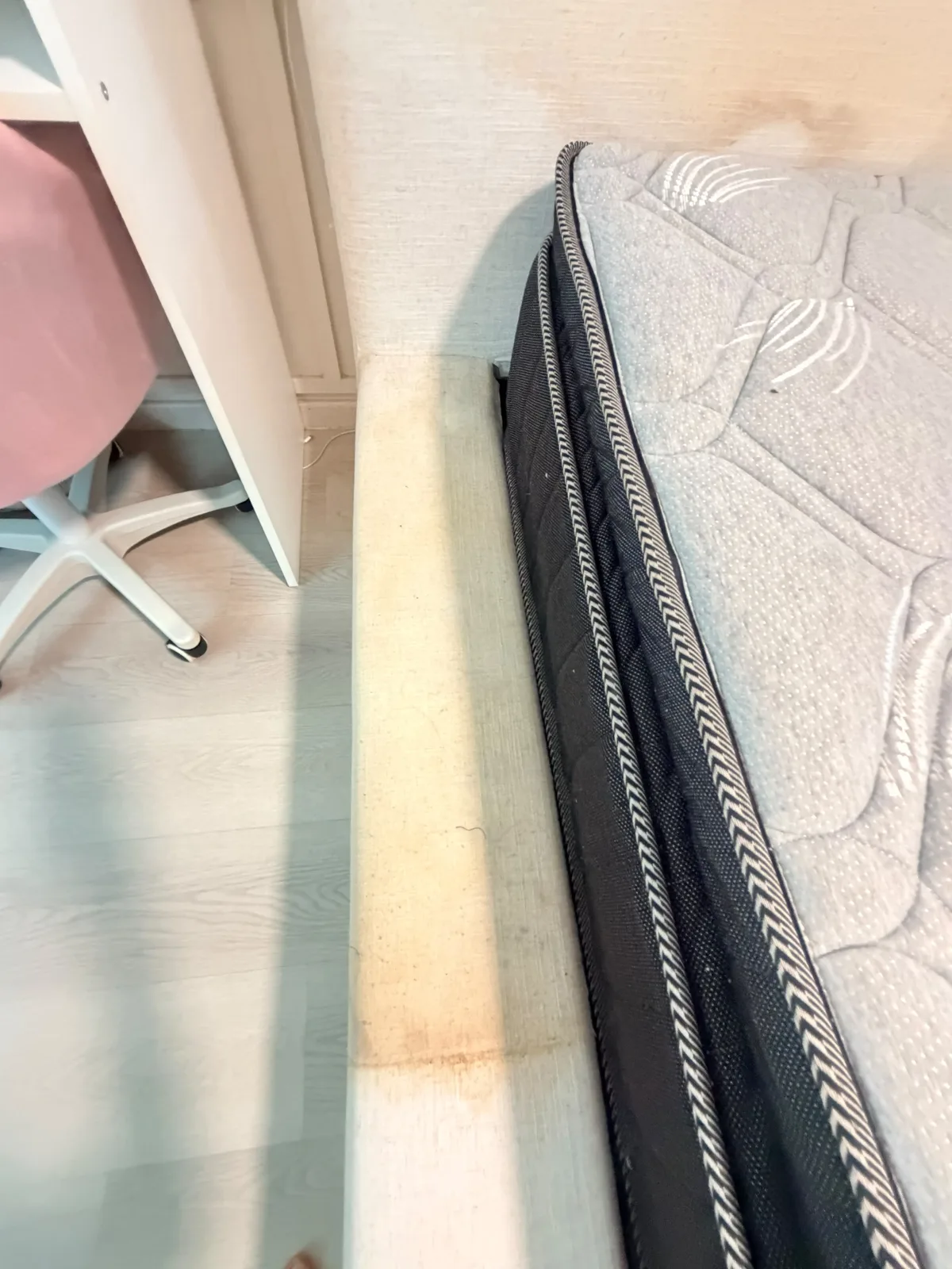 Mattress before deep cleaning — stained edge and bed base detail