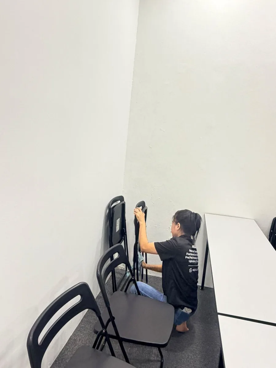 Worker lifting chairs for thorough floor and chair clean