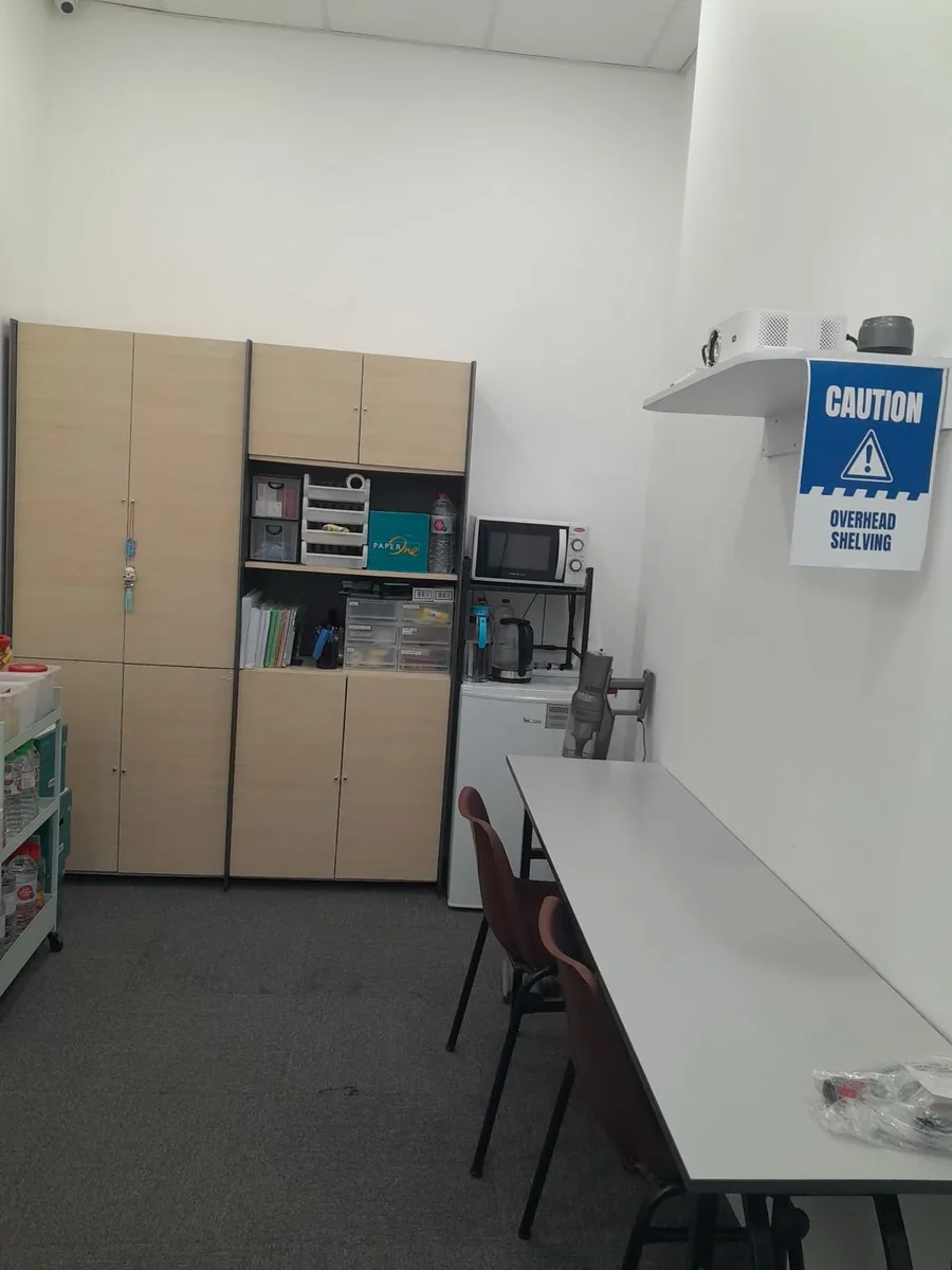 Office pantry area with wooden cabinets and appliances โ after clean