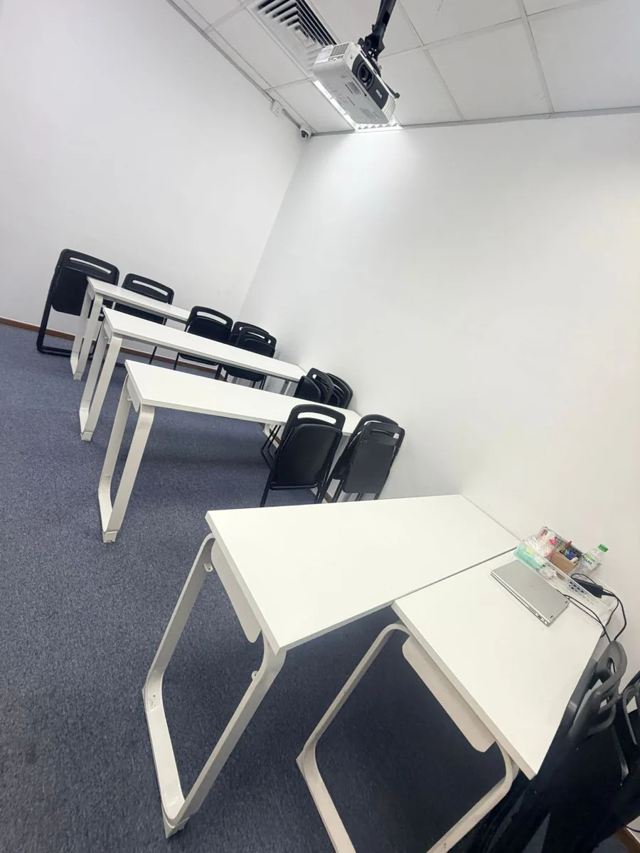 Clean training room result โ white tables and carpeted floor