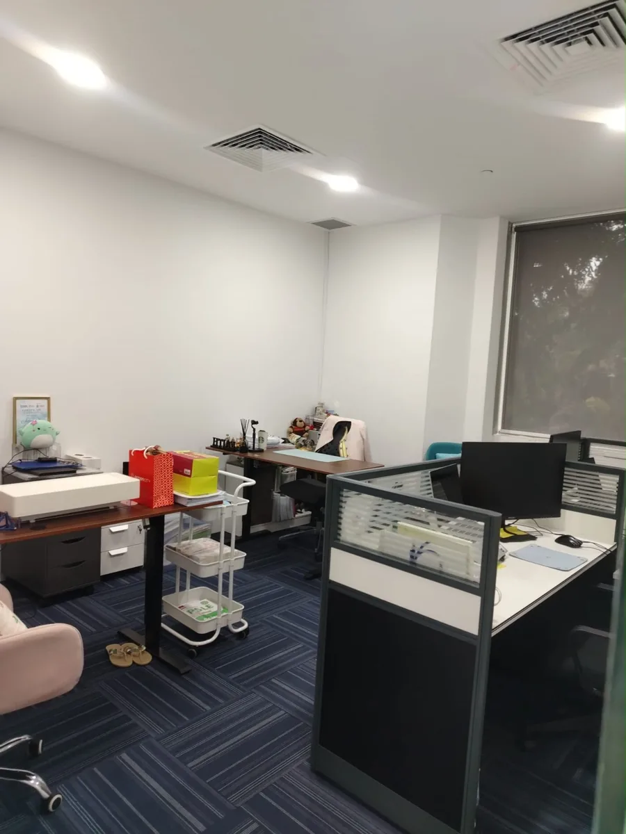 Office workspace before cleaning โ desks, equipment and supplies in place