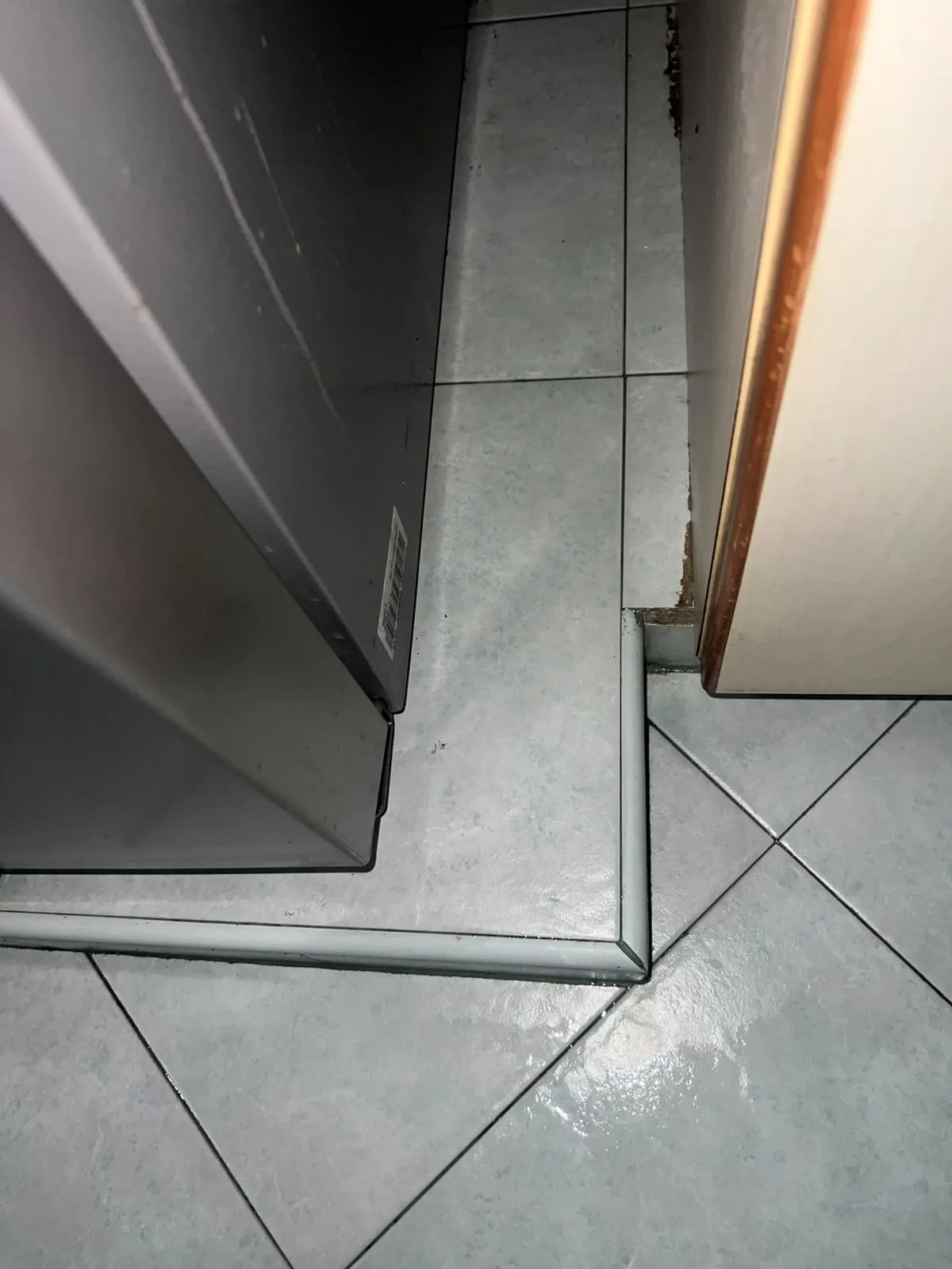 Post-tenancy after cleaning โ floor beside refrigerator scrubbed clean