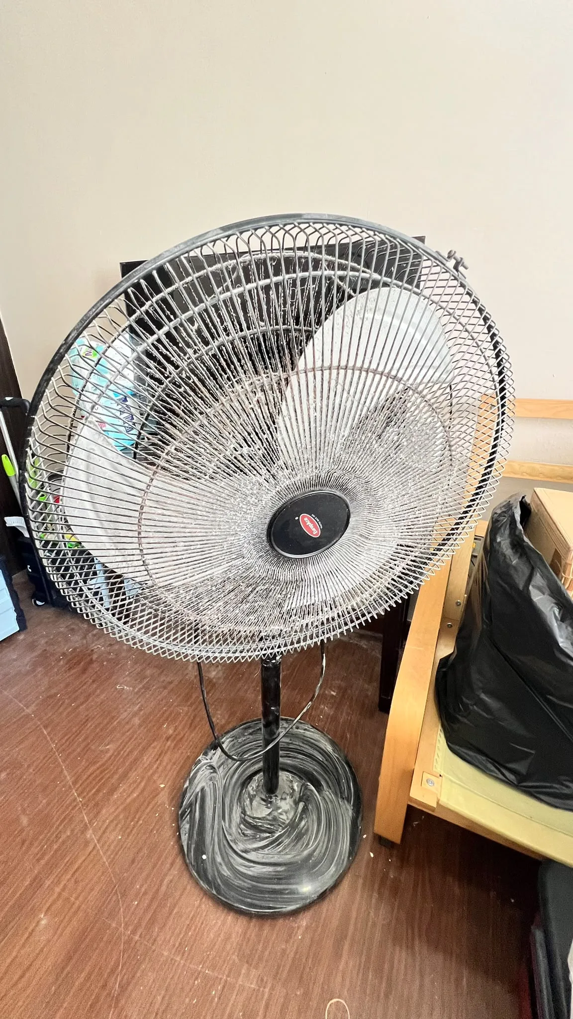 Living hall before post-renovation cleaning โ standing fan and stored items on dusty flooring